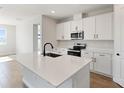 Modern kitchen featuring white cabinets, quartz countertops, and stainless steel appliances at 4256 Sawtooth Ct, Tavares, FL 32778