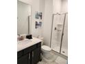 Clean bathroom with dark vanity, white shower, and marble-look floor at 1058 Splash Shot Pl, Davenport, FL 33896