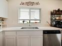 Modern kitchen with white cabinets, quartz countertops, and a stainless-steel dishwasher at 2894 Mosshire Cir, Saint Cloud, FL 34772