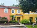 Townhome with yellow and coral exterior and landscaping at 3189 Yellow Lantana Ln, Kissimmee, FL 34747