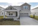 Two-story house with gray siding, stone accents, and a two-car garage at 4236 Sawtooth Ct, Tavares, FL 32778