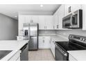 Modern kitchen with white cabinets, stainless steel appliances, and an island at 4236 Sawtooth Ct, Tavares, FL 32778