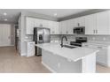 Modern kitchen with white cabinets, stainless steel appliances, and a large island at 4236 Sawtooth Ct, Tavares, FL 32778