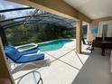 Relaxing screened-in pool and spa area with lounge chairs at 2143 Victoria Dr, Davenport, FL 33837