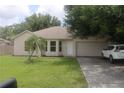 One-story house with attached garage and landscaped lawn at 624 Gull Dr, Poinciana, FL 34759