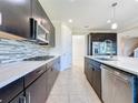 Modern kitchen with dark cabinets and stainless steel appliances at 3510 Mediterra Dr, Clermont, FL 34711