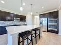 Modern kitchen with dark cabinetry, quartz countertops, and stainless steel appliances at 3510 Mediterra Dr, Clermont, FL 34711