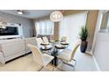 Dining area with glass table and six white chairs at 5144 Adelaide Dr, Kissimmee, FL 34746