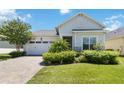 One-story home with light gray siding, white door, and brick paver driveway at 5006 Sunfalls Ave, Saint Cloud, FL 34772