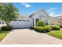 Front view of a one-story house with a white garage door and landscaped yard at 5006 Sunfalls Ave, Saint Cloud, FL 34772