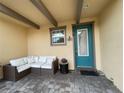 Cozy patio area with seating and a teal front door at 8079 Nemours Pkwy, Orlando, FL 32827