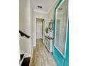 Bright entryway with tile flooring, decorative console table, and teal door at 8079 Nemours Pkwy, Orlando, FL 32827