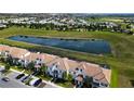 Aerial view of townhouses, pond, and community at 8971 Stinger Dr, Davenport, FL 33896