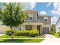 Two story house with light beige siding and dark roof at 8963 Amelia Downs Trl, Kissimmee, FL 34747