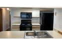 Kitchen with black appliances and double sink at 2717 N Poinciana Blvd # 179, Kissimmee, FL 34746
