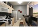 Galley kitchen with white appliances and granite countertops at 2305 Silver Palm Dr # 302, Kissimmee, FL 34747