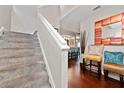 Gray carpeted staircase leading to the upper level of the home, with a view of the living area at 1105 Monroe Ave., Saint Cloud, FL 34769