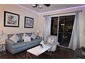 Living room with grey sofa, coffee table, and access to a balcony at 7671 Comrow St # 302, Kissimmee, FL 34747