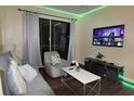Living room with grey sofa, coffee table, and large TV at 7671 Comrow St # 302, Kissimmee, FL 34747