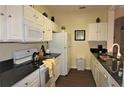 Modern kitchen with white cabinets, black countertops, and stainless steel appliances at 7671 Comrow St # 302, Kissimmee, FL 34747