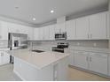 Modern kitchen featuring white cabinets, stainless steel appliances, and an island at 2035 Stetson Ct, Eagle Lake, FL 33839