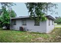 Rear view of a gray house with AC unit and yard at 225 E Pomelo St, Lake Alfred, FL 33850