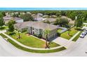 Aerial view of a two-story home with a green exterior, palm trees, and a landscaped yard at 5051 Plymouth Turtle Cir, St Cloud, FL 34772