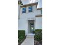 Inviting exterior of a two-story townhome featuring a teal front door and well-manicured landscaping at 1539 Carey Palm Circle Pl, Kissimmee, FL 34747