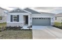 Curb appeal of a charming one-story house with gray siding and stone accents at 4244 Sawtooth Ct, Tavares, FL 32778