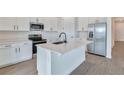 Modern kitchen with white cabinets, stainless steel appliances, and an island at 4244 Sawtooth Ct, Tavares, FL 32778