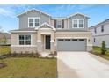 Two-story house with gray siding, stone accents, and a gray garage door at 4255 Sawtooth Ct, Tavares, FL 32778