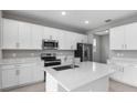 Modern kitchen with white cabinets, stainless steel appliances, and an island at 4255 Sawtooth Ct, Tavares, FL 32778