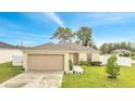 Single-story home exterior view with beige siding, two-car garage, and front yard at 47 Willow Ln, Kissimmee, FL 34759