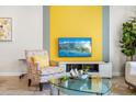Living room with a yellow accent wall, TV and comfy seating at 880 Pebble Beach Dr, Davenport, FL 33896