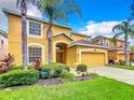 Two-story house with a two-car garage and well-manicured lawn at 1038 Orange Cosmos Blvd, Davenport, FL 33837