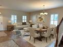 Bright living room with dining area, hardwood floors, and large windows at 108 Colonial Pine Ln, Minneola, FL 34715