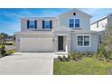 Two-story house with light beige siding, gray shutters, and a two-car garage at 308 Alexandrite St, Deland, FL 32720