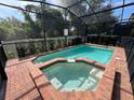 Relaxing screened-in pool and spa area with brick decking at 1921 Nice Ct, Kissimmee, FL 34747