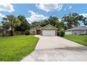 House exterior showcasing a two-car garage and landscaped lawn at 607 Powell St, Wildwood, FL 34785