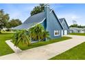 Blue house with a long driveway and lush green landscaping at 435 Lantern Dr, Kenansville, FL 34739