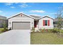 Curb appeal! One-story home with gray siding, red shutters, and a two-car garage at 2027 Stetson Ct, Eagle Lake, FL 33839