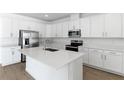 Modern kitchen featuring white cabinets, quartz countertops, and stainless steel appliances at 2027 Stetson Ct, Eagle Lake, FL 33839