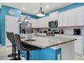 Modern kitchen with white cabinets, granite island, and blue walls at 3725 Pacific Ln, Davenport, FL 33897
