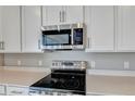 Modern kitchen with stainless steel appliances and white cabinets at 1413 August Gray Dr, Kissimmee, FL 34744