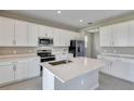 Modern kitchen featuring white cabinets, stainless steel appliances, and a large island at 1413 August Gray Dr, Kissimmee, FL 34744