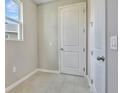 Bright laundry room with tile flooring and a white door at 1413 August Gray Dr, Kissimmee, FL 34744