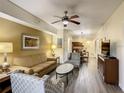 Bright living room featuring hardwood floors, comfortable seating, and a view of the dining area at 12544 Floridays Resort Dr # 202B, Orlando, FL 32821