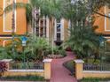 Building entrance with landscaped courtyard and walkway at 12538 Floridays Resort Dr # C-211, Orlando, FL 32821