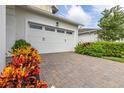 Two-car garage with white doors and brick driveway at 5012 E Fountainwood Dr, St Cloud, FL 34772