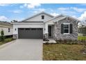 New single-story home with stone and shingle accents, two-car garage, and landscaped front yard at 4056 Bannock Ave, Tavares, FL 32778